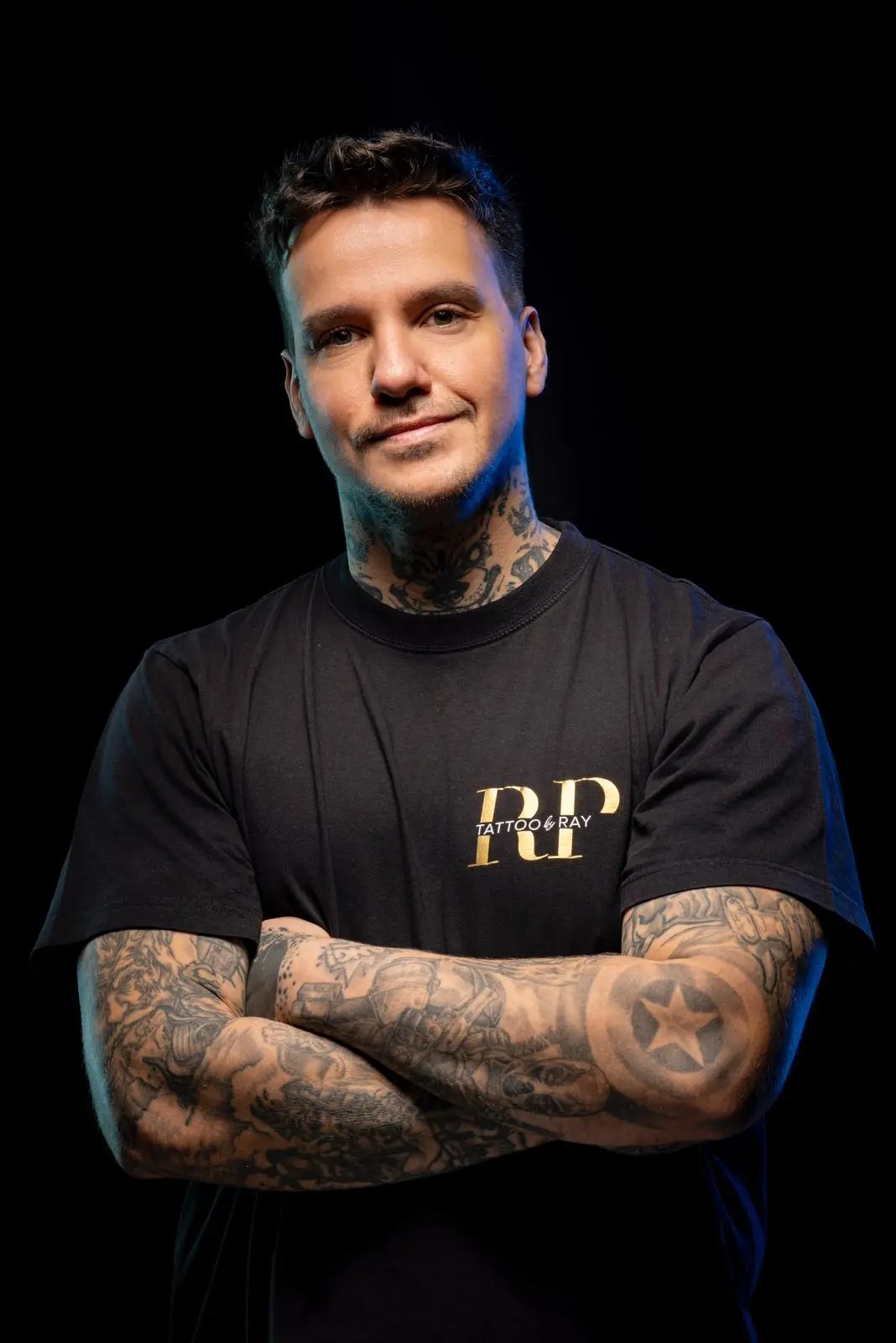 Tattoo Artist Ray (Raimund Petrov) mit verschränkten Armen – professionelles Porträt im Studio-Look